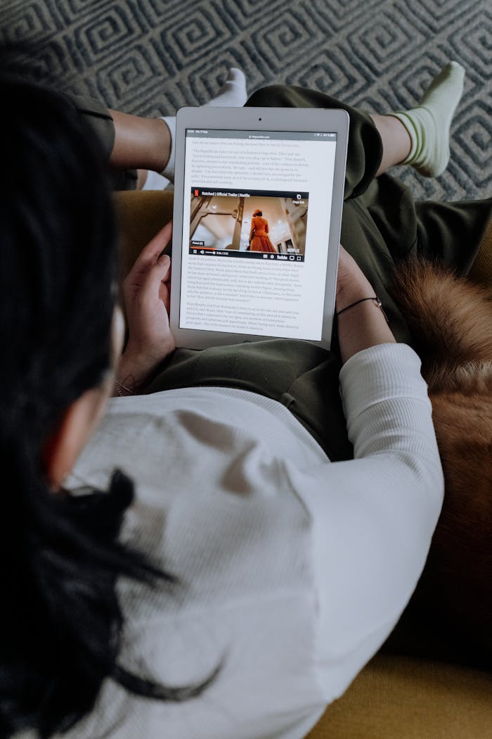 Woman in White Long Sleeve Shirt Holding a Tablet